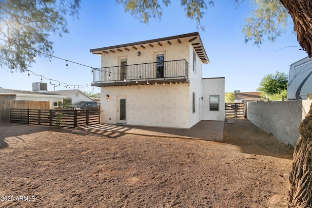 21647 W Laura St, Wittmann, AZ 85361 - back of house featuring a balcony, stucco siding, a fenced backyard, and a patio area
