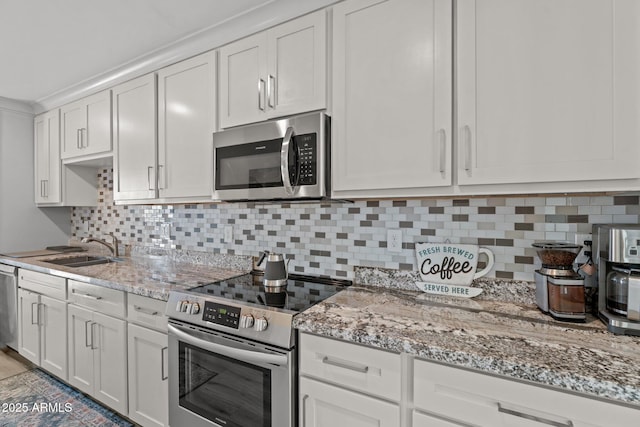 21647 W Laura St, Wittmann, AZ 85361 - kitchen featuring stainless steel appliances, light stone countertops, decorative backsplash, and white cabinetry
