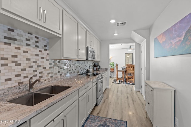 21647 W Laura St, Wittmann, AZ 85361 - kitchen featuring appliances with stainless steel finishes, recessed lighting, backsplash, ceiling fan, and light wood-type flooring