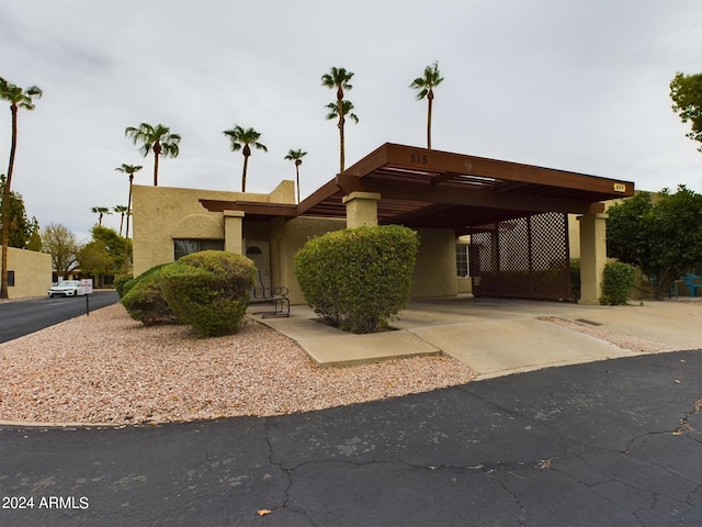 exterior space with driveway, an attached carport, and stucco siding