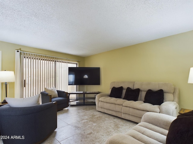 living room with a textured ceiling and tile patterned flooring