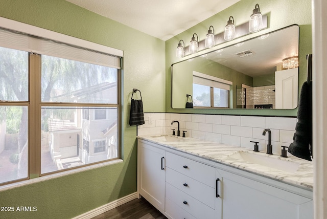 1145 E Lowell Ave, Gilbert, AZ 85295 - bathroom with a textured wall, backsplash, wood finished floors, double vanity, and baseboards