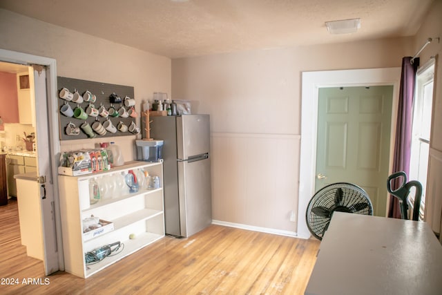 kitchen with stainless steel refrigerator and light hardwood / wood-style flooring