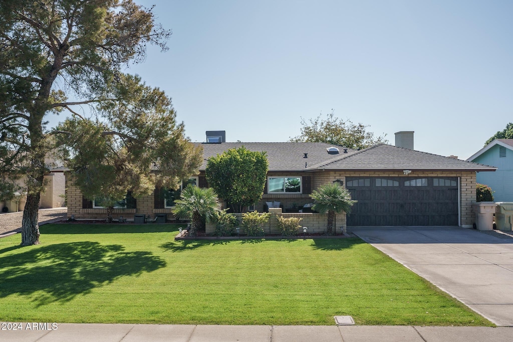 view of front of property with a front yard and a garage