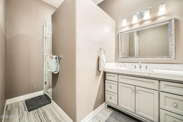 12448 N 129th Pl, Scottsdale, AZ 85259 - full bathroom with vanity, a textured wall, a stall shower, and baseboards
