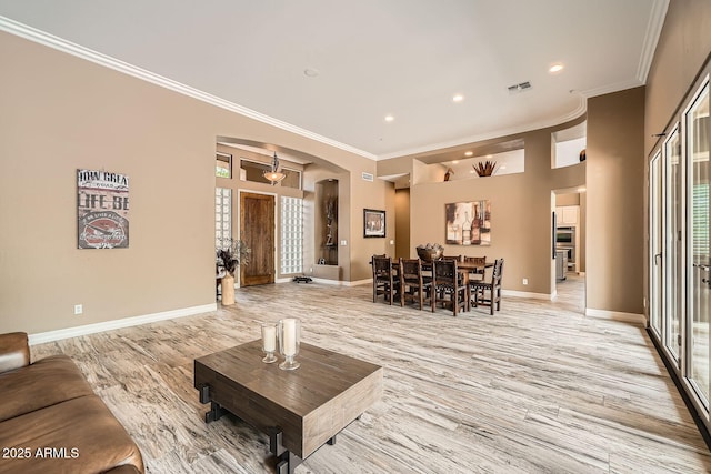 12448 N 129th Pl, Scottsdale, AZ 85259 - living area featuring arched walkways, light wood-style flooring, baseboards, crown molding, and recessed lighting