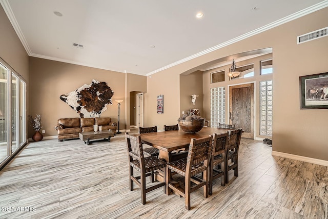 12448 N 129th Pl, Scottsdale, AZ 85259 - dining area with arched walkways, light wood-style flooring, baseboards, and ornamental molding