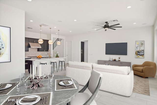 dining room featuring light tile patterned flooring, sink, and ceiling fan