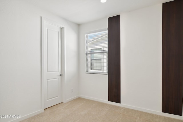 spare room featuring light colored carpet