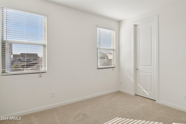 carpeted spare room featuring plenty of natural light