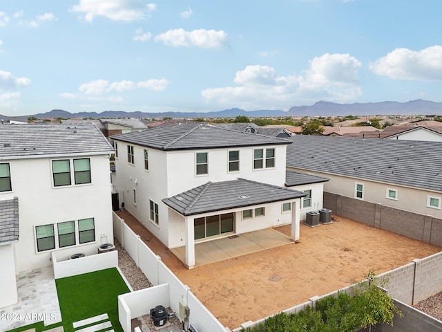 rear view of house featuring central AC unit, a mountain view, and a patio area