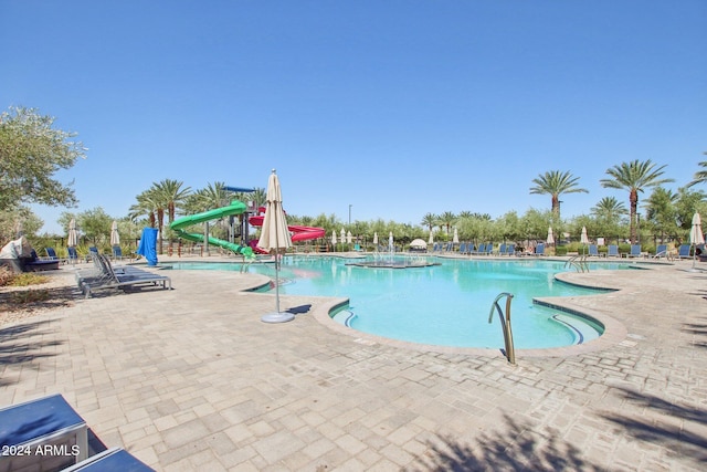 view of swimming pool with a patio and a water slide