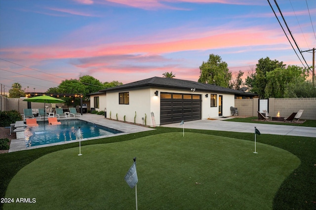 pool at dusk with a patio area