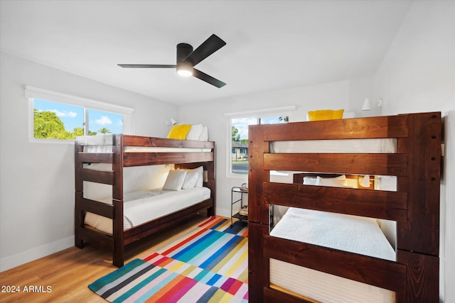 bedroom featuring multiple windows, ceiling fan, and wood-type flooring