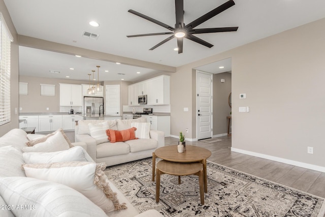 living room featuring ceiling fan and hardwood / wood-style floors