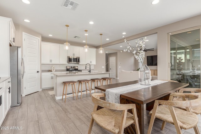 dining room featuring sink and light hardwood / wood-style floors