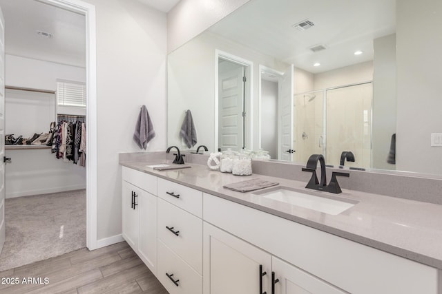 bathroom with a shower with door and vanity