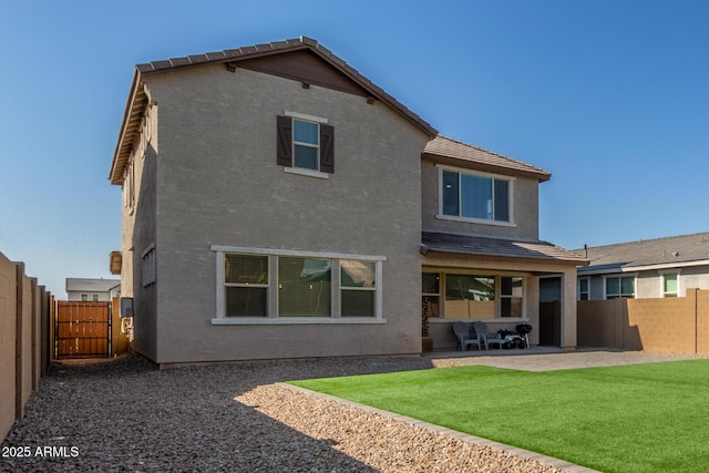 rear view of property with a yard and a patio