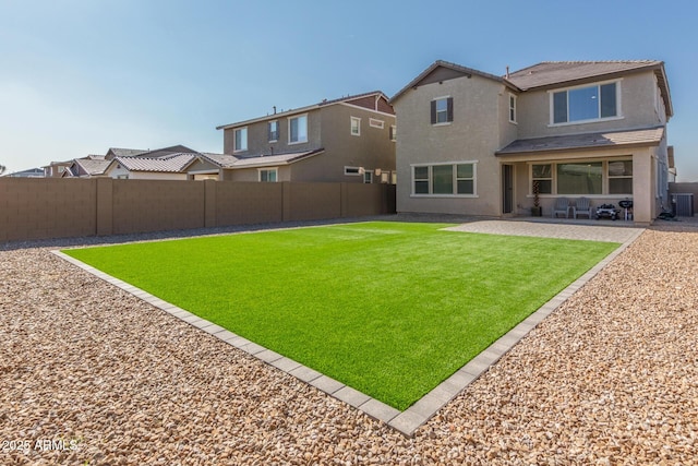 rear view of house with a lawn and a patio area