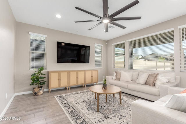 living room with ceiling fan, light hardwood / wood-style flooring, and a healthy amount of sunlight