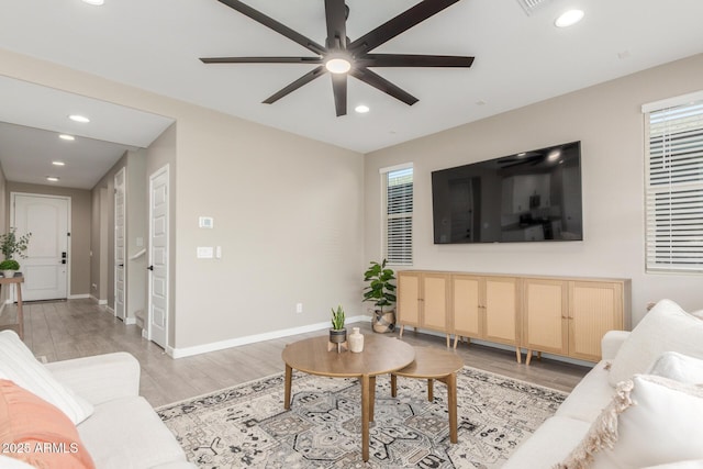 living room with ceiling fan and light hardwood / wood-style floors