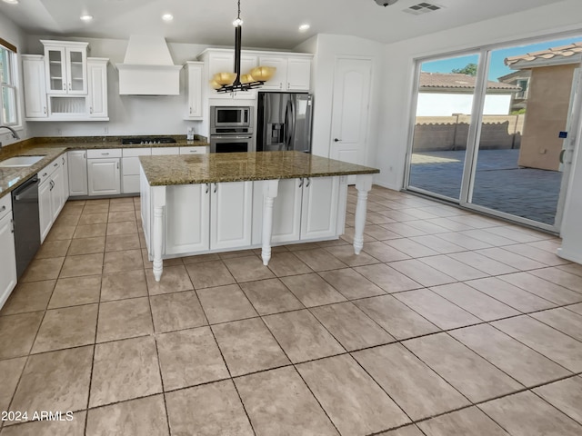 kitchen with appliances with stainless steel finishes, a center island, a sink, and custom exhaust hood