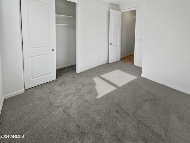 unfurnished bedroom with baseboards, a closet, and light colored carpet