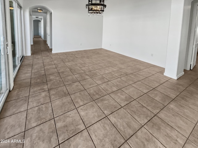 unfurnished dining area with arched walkways and a chandelier