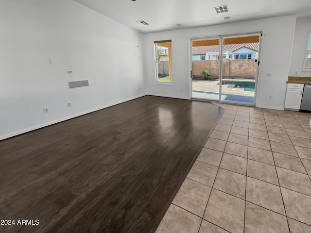 unfurnished living room featuring light wood-type flooring, visible vents, and baseboards