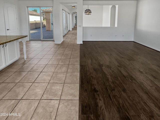 interior space with an inviting chandelier, light wood-style flooring, and baseboards