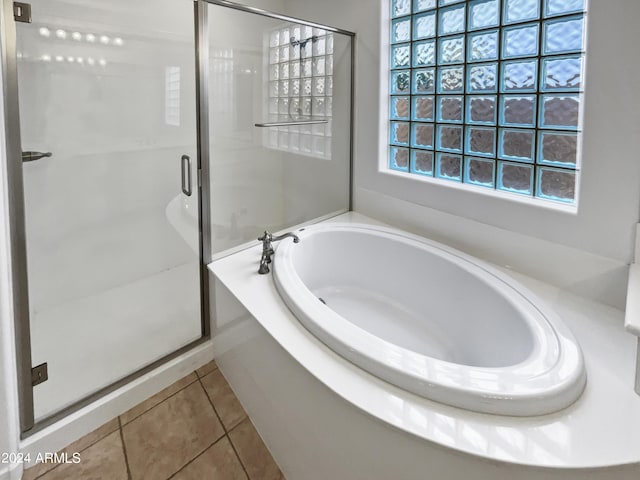 bathroom featuring a garden tub, a shower stall, and tile patterned flooring