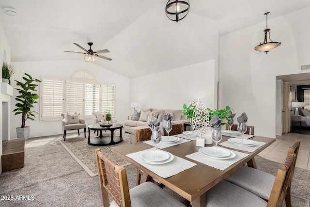 dining room featuring visible vents, light tile patterned flooring, ceiling fan, vaulted ceiling, and light carpet