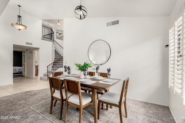 dining area with stairway, light colored carpet, and visible vents