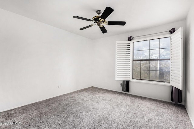 carpeted spare room with a ceiling fan