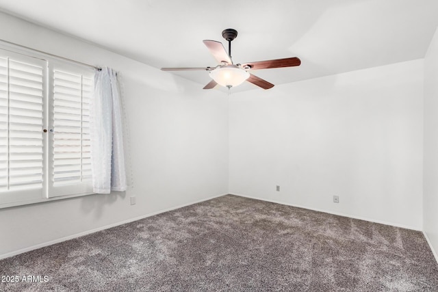 carpeted spare room featuring baseboards and ceiling fan