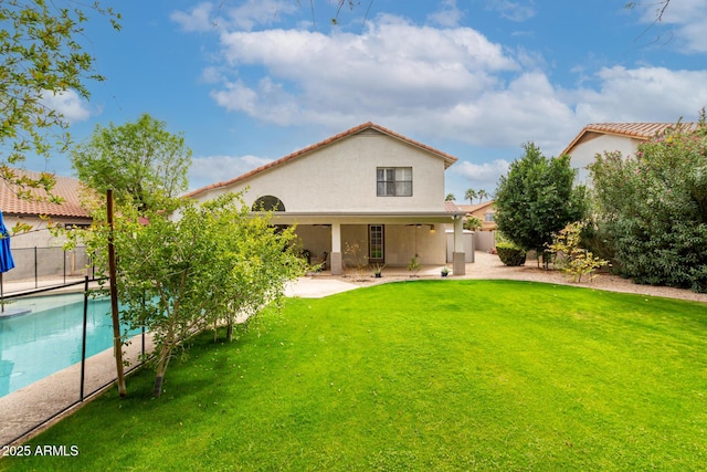 back of house with a yard, a patio area, stucco siding, and fence