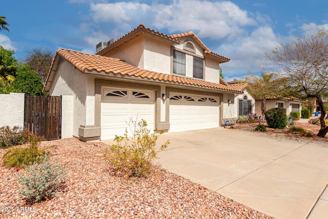 mediterranean / spanish-style house featuring stucco siding, fence, driveway, and a tiled roof