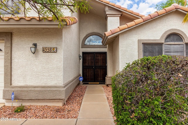 property entrance featuring stucco siding and a tiled roof