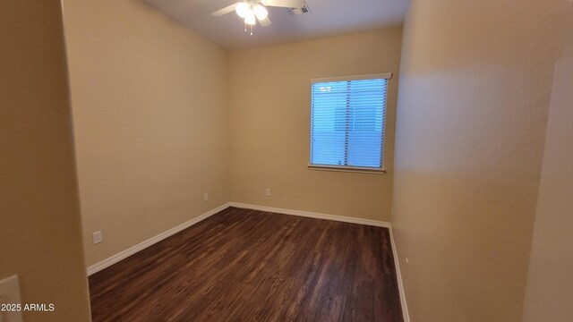 empty room featuring dark wood-style floors, baseboards, visible vents, and a ceiling fan