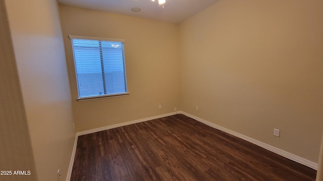 empty room with baseboards and dark wood finished floors