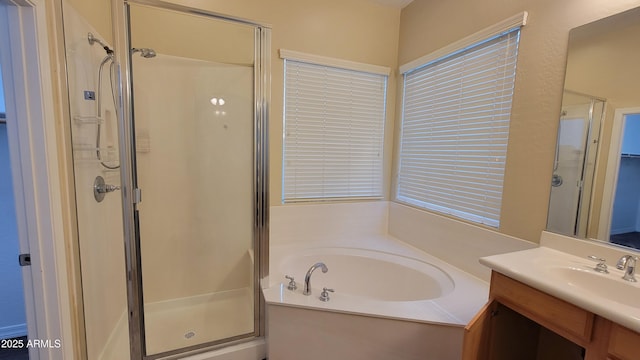 bathroom with a garden tub, a shower stall, and vanity