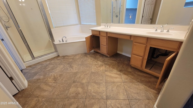 full bath with double vanity, a garden tub, a shower stall, and a sink