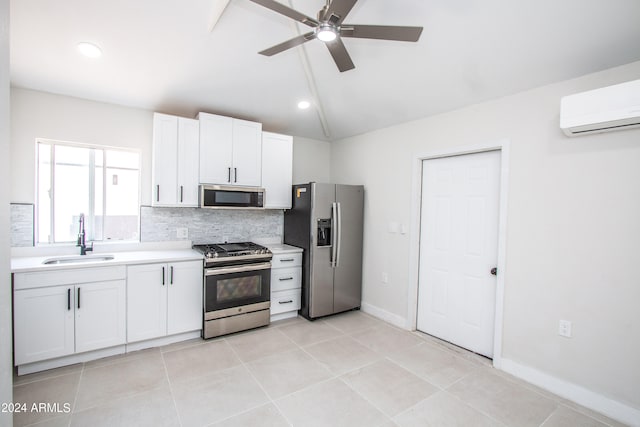 kitchen featuring appliances with stainless steel finishes, white cabinets, backsplash, an AC wall unit, and sink