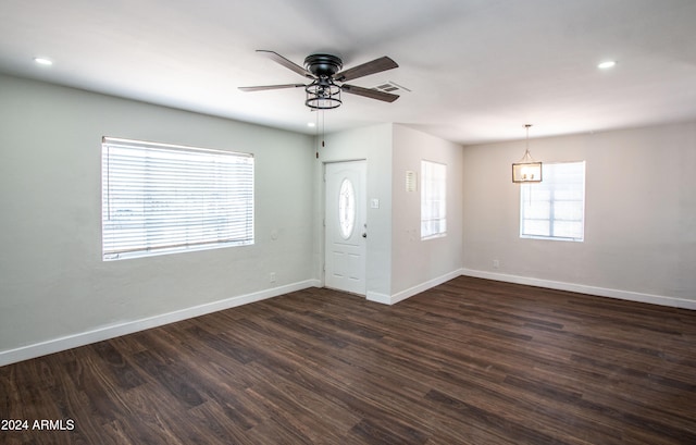 entryway with ceiling fan with notable chandelier and dark hardwood / wood-style flooring