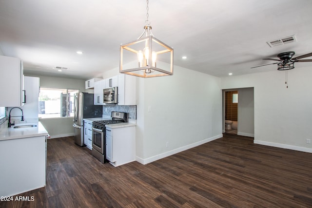 kitchen with sink, white cabinets, stainless steel appliances, decorative light fixtures, and dark hardwood / wood-style flooring