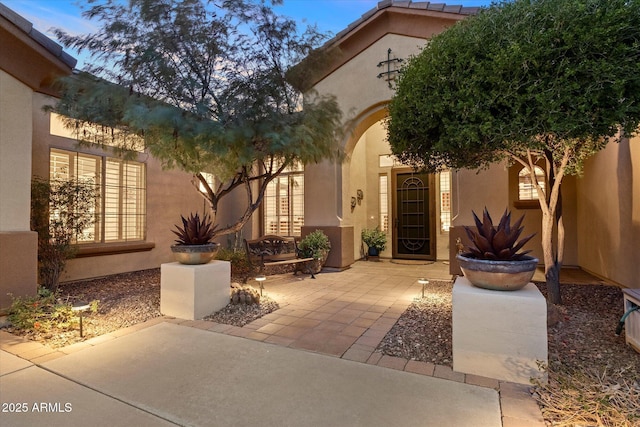 view of exterior entry featuring a patio area