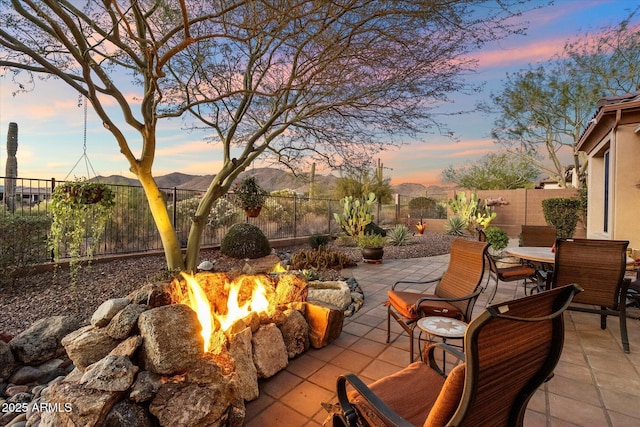 patio terrace at dusk with a mountain view and an outdoor fire pit