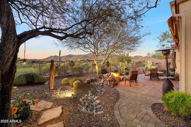 patio terrace at dusk with a mountain view and a fire pit