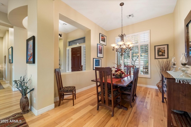 dining area featuring a notable chandelier and light wood-type flooring