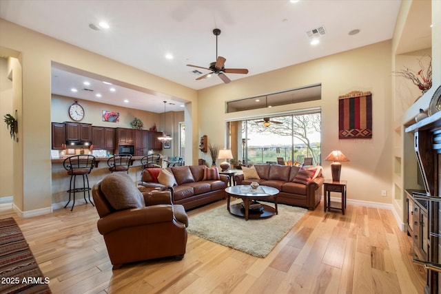 living room with ceiling fan and light hardwood / wood-style floors